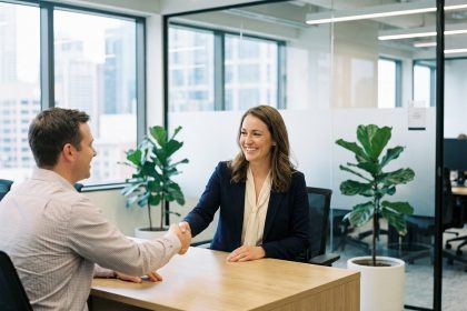 Femme souriante serrant la main d'un client dans un bureau moderne